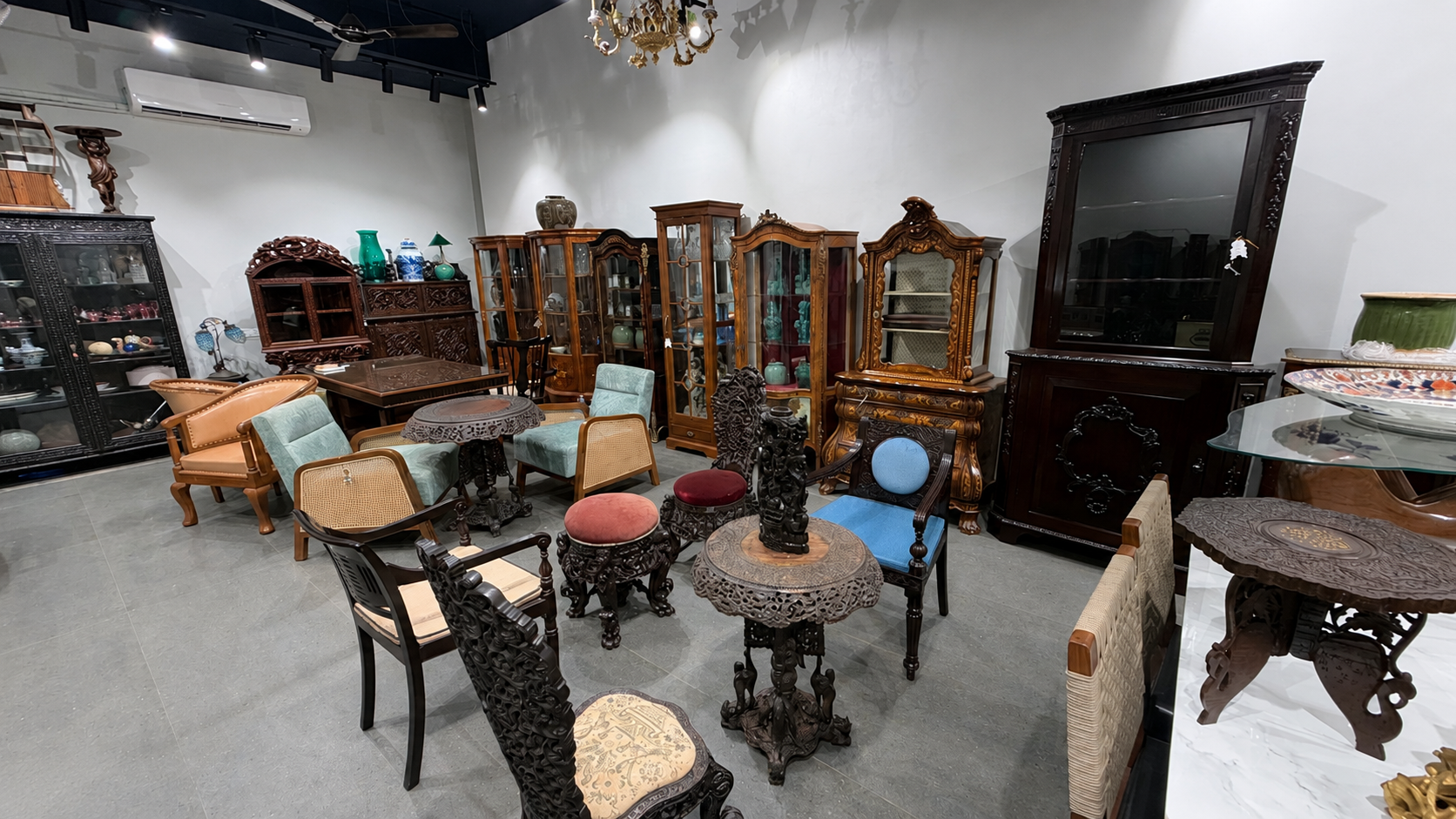 Vinterior showroom — carved seating, Anglo-Indian chairs and vitrines